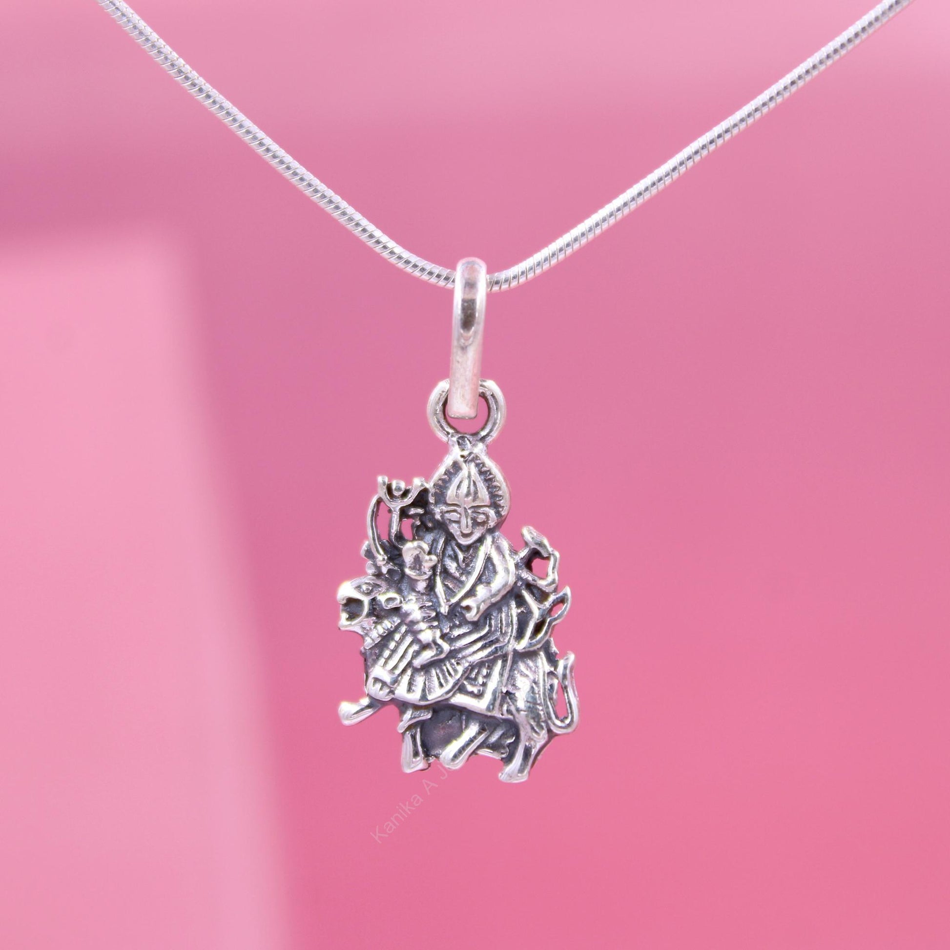Sterling silver goddess pendant on a pink background
