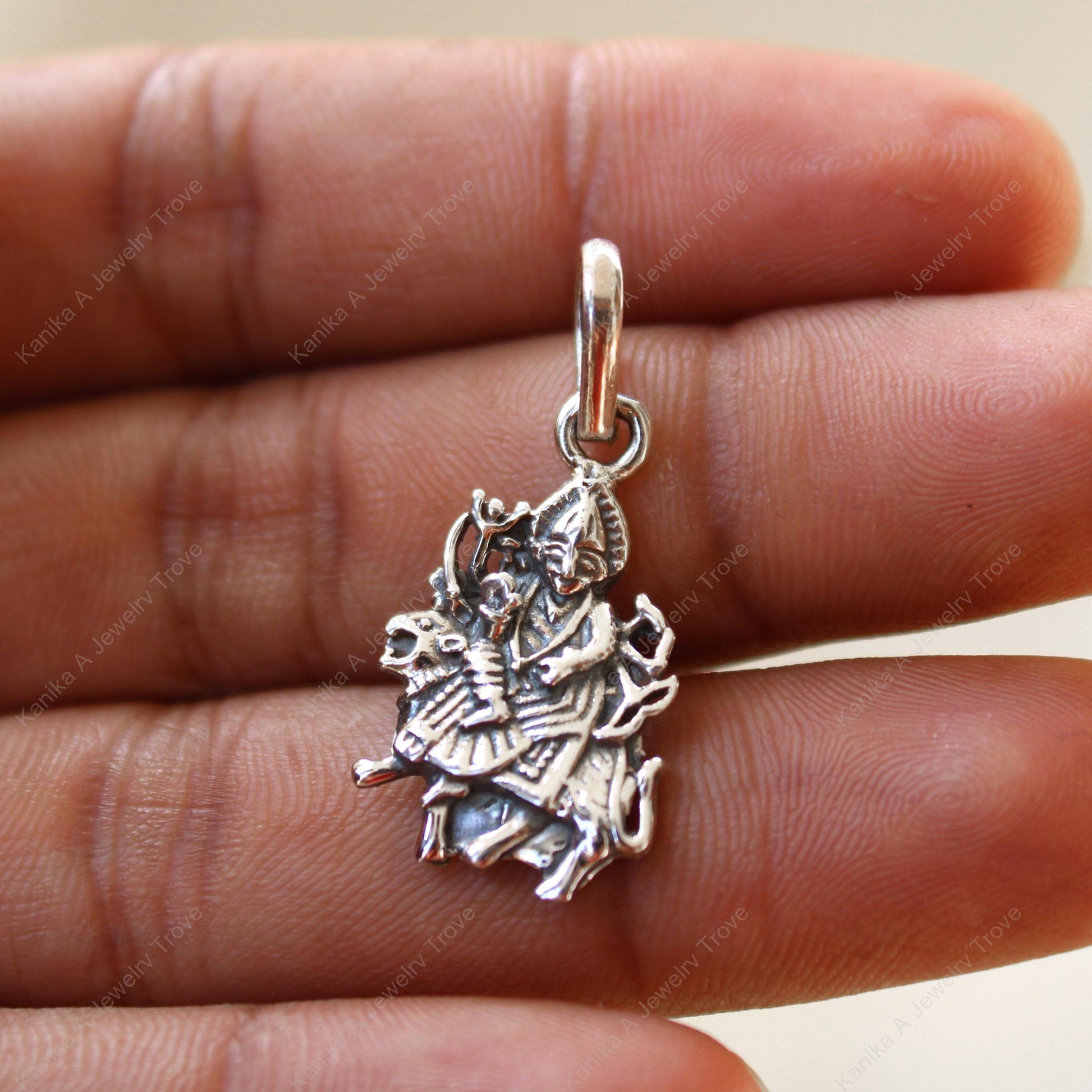 Close-up of intricate goddess design in silver pendant